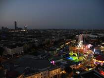 Der Horizont versinkt in der Nacht und im Prater locken die im Neonlicht strahlenden Schaustellgeschfte. Blick auf den Prater hinunter vom Wiener Riesenrad. Wien, 19.07.2014