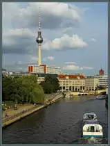 Der 1965 bis 1969 am Alexanderplatz errichtete Fernsehturm ist ein weithin sichbares Wahrzeichen Berlins. Gleichzeitig ist der Turm mit mehr als einer Million Besuchern im Jahr eine der meistbesuchten Sehensw&uuml;rdigkeiten Deutschlands. Rechts ist der Turm des Roten Rathauses erkennbar, im Vordergrund die Spree. Das Foto entstand nahe der Museumsinsel w&auml;hrend der Fahrt &uuml;ber die Stadtbahn. (07.08.2014)