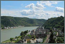 Blick vom Schlossberg auf Sankt Goar: Im Vordergrund das Zentrum von St. Goar mit der katholischen Pfarrkirche, dahinter die evangelische Stiftskirche. Rechts der Rheinstrecke sind zwei Wehrtrme erhalten geblieben. Auf der anderen Seite des Rheins befindet sich Sankt Goarshausen mit der Kirche St. Johannes. ber dem Ort tront die Burg Katz. (09.08.2014)