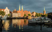Treppengiebel und Backsteinbauweise prgen das Bild der Hansestadt Lbeck. In kontrastreicher Lichtstimmung erstrahlen die Gebude am Holstenhafen entlang der Strae An der Untertrave und auf der Altstadtinsel. Die sichtbaren Kirchtrme gehren zur Marienkirche (links) und zur Petrikirche (rechts). Die Lbecker Altstadt ist Teil des UNESCO-Welterbes. (05.08.2014)
