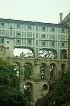 Schloss Česk� Krumlov - Mantelbr�cke  (14.9.2014)
Die Mantelbr�cke ist eine mehrst�ckige Br�cke in Česk� Krumlov,die den Burggraben des dortigen Schlosses �berspannt.
Der offene Durchgang verbindet zwei H�fe des Schlosses miteinander. Dar�ber befinden sich zwei weitere geschlossene Stockwerke, mit einem weiteren Zwischengeschoss, die die Geb�ude auf beiden Seiten verbinden. Erstmals erw�hnt wurde die Br�cke im 15. Jahrhundert; das heutige Aussehen der Br�cke stammt aus dem Jahr 1777. Zusammen mit dem Schloss z�hlt die Br�cke zum UNESCO-Welterbe.




