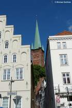 Der Turm der Petrikirche in Kbeck schaut zwischen den Altstadthusern an der Trave durch (Mai 2011)