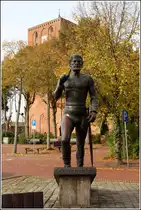 Marienhafe. Das St�rtebeker-Denkmal mit der St.-Marien-Kirche im Hintergrund. Zu St�rtebekers Lebzeiten war Marienhafe noch Hafenort. Der Kirchturm soll St�rtebeker von 1396 bis 1400 bei seinen Aufenthalten in Marienhafe als Wohnung gedient haben. 18.10.2014