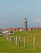 . Juist - Der Leuchtturm vom Yachthafen aus gesehen. 10.10.2014 (Jeanny)

Ursprnglich besa Juist keinen eigenen Leuchtturm. Die Leuchtfeuer der benachbarten Inseln Borkum und Norderney reichten zur Orientierung der Schifffahrt aus. Dass es seit Ende 1992 doch einen kleinen Leuchtturm auf der Insel gibt, ist einer Interessengemeinschaft bestehend aus dem Heimatverein Juist, dem Segelklub Juist und der Anglergemeinschaft  NO.PO.NI.RE Fischereigenossenschaft AG  zu verdanken. Die Interessengemeinschaft erwarb das in Emden gelagerte Laternenhaus des 1986 stillgelegten Leuchtfeuers der benachbarten Vogelschutzinsel Memmert. Der dazugehrige Turm wurde in Hafennhe neu gebaut und mit dem gekauften Laternenhaus ausgestattet. Das „Memmertfeuer“ hat fr die Schifffahrt keine Bedeutung, sondern dient ausschlielich touristischen Zwecken. Daher schickt er seine Lichtsignale im 13-Sekunden-Takt auch in Lngsrichtung ber die Insel, damit sein Leuchtfeuer von See her nicht gesehen werden kann. Von April bis Oktober kann der Leuchtturm bestiegen werden