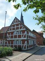 Jork-Borstel im Alten Land: Frei stehender Turm der ev. St. Nikolai-Kirche versteckt hinter dem Fachwerkhaus (Juli 2014)
