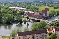 Wenn man die �ber 200 Stufen des Turms der Kirche St. Marien-Andreas erklommen hat, bietet sich ein �berw�ltigender Ausblick auf Rathenow, einer der Orte der BUGA 2015. Hier sieht man den n�rdlichen Zugang zum BUGA-Gel�nde Optikpark, davor der oft abgelichtete, aber sonst funktionslose Leuchtturm. Am 30.05.2015 hat da oben ein kr�ftiger Wind das verwackelungsfreie Fotografieren schon etwas erschwert.
