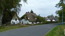 Reetdach gedeckte Huser in einer ruhigen Nebenstrae von Middelhagen mit schiefer Laterne (Mnchgut, Rgen, September 2012)
