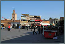 Am Platz Djama el-Fna in Marrakesch befinden sich auch zahlreiche Garkchen und Restaurants. Besonders begehrt sind die Terrassen auf den Dchern, da sie einen guten Blick ber das Getmmel des Platzes bieten. Ein beliebtes Gericht der marokkanischen Kche ist Tajine, welche in den kegelfrmigen Gefen, die auf dem rechten Wagen zu sehen sind, zubereitet wird. ber einem Holzkohlefeuer knnen die Gerichte (Fisch, Fleisch oder Gemse) langsam gegart werden. (Marrakesch, 17.11.2015)