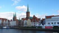 Blick ber die Trave auf die Trme der Marienkirche links und Petrikirche rechts; am Ufer ist eine Kindereisbahn zu sehen (Lbeck, 30.12.2012)
