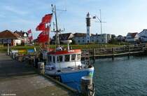 Fischerboote im Hafen und dahinter der Leuchtturm in Timmendorf auf der Insel Poel (Landkreis Nordwestmecklenburg, November 2011)
