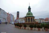 Die Wasserkunst von 1602 am Marktplatz mit Weihnachtsmarkt, dahinter der Turm der Marienkirche (Hansestadt Wismar, Dezember 2011)
