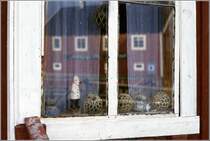 Henningsvr. Im Fenster spiegelt sich die Galleri Karl Erik Harr. Scan eines Dias vom Juni 1994.