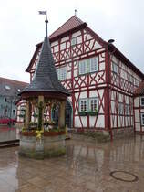 Stadtlauringen, altes Rathaus am Marktplatz, zweigeschossiger Fachwerkbau mit einseitig abgewalmten Satteldach und dreischiffiger Halle im Erdgeschoss, erbaut 1563 (25.03.2016)