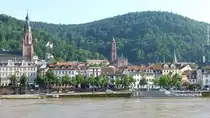 Hinter dem Neckar ragen die T�rme der Heiliggeistkirche und Jesuitenkirche �ber den H�usern der Altstadt in Heidelderg (Juni 2016)