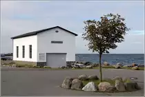 Vang. Vom Ende des 19. Jahrhunderts bis zur Schlie�ung des nahegelegenen Granitsteinbruchs 1970 war der Ort Zentrum der Steinbearbeitung. Dieses Geb�ude wurde 1946 f�r  Vang Stenbuggerier  errichtet. Heute ist hier eine Gallerie beheimatet. 23.08.2016