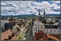 Die Darrtorstra�e in Saalfeld f�hrt vom namensgebenden Stadttor, das als Aufnahmeort diente, zum Markt. Am Ende der Stra�e ist die aus dem 15. Jahrhundert stammende Marktapotheke zu erkennen. �berragt werden die D�cher der Altstadt von den T�rmen der Johanneskirche, welche von 1380 bis 1514 erbaut wurde und die gr��te Hallenkirche Th�ringens ist. (Saalfeld, 04.09.2016)