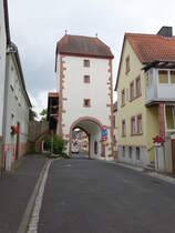 Neubrunn, Torturm der Ortsbefestigung, Durchfahrt mit Rundbogen und Spitzbogen, darber drei Geschosse und Halbwalmdach, Mitte 15. Jahrhundert (15.06.2016)