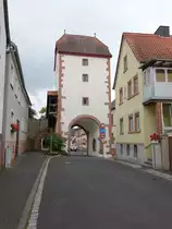 Neubrunn, Torturm der Ortsbefestigung, Durchfahrt mit Rundbogen und Spitzbogen, dar�ber drei Geschosse und Halbwalmdach, Mitte 15. Jahrhundert (15.06.2016)