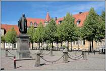 Das Justus-Mser-Denkmal auf der Groen Domsfreiheit in Osnabrck. Samstag berragt es die Verkaufsstnde des Wochenmarktes. Justus Mser ist einer der bedeutendsten Osnabrcker (siehe Wikipedia). Er lebte im 18. Jahrhundert, sein Denkmal wurde 1836 errichtet. Aufnahmedatum: 15.07.2006