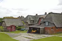 Land Dorf auf der Hallig Oland vom Deich aus gesehen. Die Halligen erheben sich nur wenige Meter �ber dem Meeresspiegel, weshalb sie w�hrend einer starken Flut mit Ausnahme der Warften, k�nstlich aufgesch�tteten H�geln, auf denen die H�user stehen, �bersp�lt werden („Landunter“). Aufnahme: 25. Juni 2017.