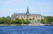 Junibacken (im Vordergrund)  ist ein Museum in Stockholm, das der schwedischsprachigen Kinderliteratur, insbesondere den Bchern Astrid Lindgrens gewidmet ist. Es befindet sich auf der Halbinsel Djurgrden. Das Nordische Museum (im Hintergrund) liegt auf der Insel Djurgrden in Stockholm und ist fr die Darstellung der Kulturgeschichte und Volksgruppen in Schweden verantwortlich.
Aufnahme: 26. Juli 2017.