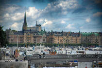 Blick auf Stockholm von Skeppsbron an der Altstadt Gamla Stan.  Im Vordergrund sieht man die Brcke Skeppsholmsbron und im Hintergrund die Kirche Oskarskyrkan.
Aufnahme: 25. Juli 2017.