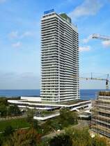 Lbeck-Travemnde: Das Maritim Hotel in unmittelbarer Strandnhe. Das Gebube wurde 1974 erbaut und ist 119 Meter hoch. Auf 36 Etagen gibt es neben einem Viersternehotel 320 Appartements, Gewerberume, Restaurants, Kegelbahnen sowie Fitness- und Wellnessbereiche. Im Dachgescho befindet sich mit 117 m das hchste Leuchtfeuer Europas. Rechts im Bild ist ein Teil eines Hotelneubaues zu sehen. Die Aufnahme enstand am 13.10.2017 vom Alten Travemnder Leuchtturm.