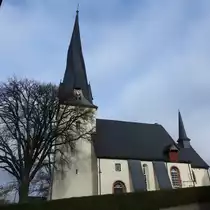 BREIDENBACH BEI BIEDENKOPF/HESSEN-EV. KIRCHE MIT  VERDREHTEM  TURM
Auf der Wegstrecke von DILLENBURG nach BIEDENKOPF/HESSEN stutzt man beim Durchfahren der Ortschaft
BREIDENBACH unwillk�rlich beim Anblick des Turms der ev. Kirche,der eigent�mlich  verdreht  erscheint....
Der achteckige,gewundene Turm der Kirche ist nat�rlich das Wahrzeichen des Ortes geworden-eine Bauform,
die es nur wenige Male in Deutschland gibt-aus der Seitenansicht ist die eigenartige Verkr�mmung
besonders gut zu erkennen...
Ob es durch Feuchtigkeit und anschlie�ende Abtrocknung des Geb�lks entstand oder ob eine Absicht der
Erbauer dahinterstand- schwer zu erkl�ren...
Auch das Innere der Mitte des 13. Jahrhunderts als sp�tromanische Wandpfeilerhalle erbauten Kirche ist
sehenswert: Das Altarkreuz mit Corpus,um 1300 gefertigt,ist ein besonderesKleinod,2 der 3 Glocken wurden
1454 und 1512 gegossen,die Orgel wurde 1768 vom Orgelbauer HEYNEMANN aus Gie�en errichtet.....
ein ganz besonderes Gotteshaus,am 1.11.2017
Zusatz:�hnlich verdrehte Kircht�rme findet man in MAYEN oder D�SSELDORF(Basilika St. Lambertus)-vermutet
werden kann hier wohl,dass man beim Bau die zu hohen Kosten GUT abgelagerten Holzes vermied und die
Zimmerleute vermutlich viel zu frisches Holz verwendeten,das sich mit der Zeit verzog und mit der Zeit
so die gesamte Turmspitze verdrehte...vielleicht war das auch in BREIDENBACH der Fall.......