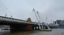 Die Eisenbahnbr�cke  Hungerford Bridge   bildet die Hauptzufahrt zum Kopfbahnhof Charing Cross. Sie wird auf beiden Seiten von Fu�g�ngerbr�cken, den  Golden Jubilee Bridges  flankiert. (London, M�rz 2013)