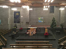 Biel/Bienne, rm.-kath. Kirche Christ-Knig, Betonbau 1967-68 von Walter Moser. Innenaufnahme der Kirche mit Blick von der Empore Richtung Chor. Der mit Weihnachtsmotiven teilweise verdeckte Altar besteht aus Marmor und wiegt 8 Tonnen. Foto nach der Mitternachtsmesse vom 25. Dez. 2017, 00:31