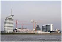 Die Havenwelten in Bremerhaven nehmen Kontur an. Das Atlantic Hotel Sail City steht kurz vor der Erffnung (01.03.2008). Unter den roten Krnen entsteht das Klimahaus 8 Ost (Fertigstellung Mrz 2009) und unter den gelben Krnen geht das Mediterraneo mit seiner hohen Glaskuppel der Vollendung entgegen (Erffnung im Sommer 2008). Rechts ist ein Wohnturm des in den 1970er Jahren entstandenen Columbus Centers zu sehen. Aufnahmedatum: 17.02.2008