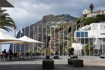 CMARA DE LOBOS (Concelho de Cmara de Lobos), 30.01.2018, auf der  Flaniermeile  vor der Kirche; rechts die Gemeindebibliothek und das Pressemuseum, im Hintergrund der Felsen mit dem Aussichtspunkt Cabo Giro