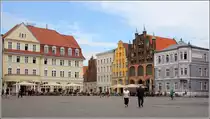 Stralsund. Die Historischen Altst�dte Stralsund und Wismar geh�ren seit 2002 zum UNESCO-Weltkulturerbe. Am Alten Markt stehen mehrere denkmalgesch�tze Geb�ude. Hier an der Nord-West-Ecke z.B. der Artushof (links), die Ratsapotheke (gelbes Geb�ude) und rechts daneben das Wulflamhaus. 28.07.2018