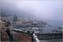 Monaco. Blick vom Stadtteil Monaco-Ville auf den unterhalb gelegenen Stadtteil La Condamine mit dem Hafen und den dahinterliegenden Stadtteil Monte Carlo. Scan eines Dias, das an einem trben Sommertag im Jahr 1979 entstand.