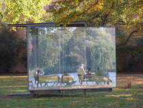 Hamburg am 11.10.2018: Spiegelungen im „Double Triangular Pavilion for Hamburg“ des Knstlers Dan Graham, in der Parkanlage „Uhlenhorster Fhrhaus“ an der Auenalster, die zu sehenden Menschen sitzen am Alsterufer /