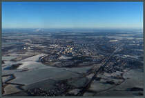 Blick auf Stendal von Westen: Die Wohnblcke des ab 1971 entstandenen Neubaugebietes Stadtsee dominieren das Stadtbild nahe dem gleichnamigen See. Rechts des Sees liegt der Bahnhof Stendal, von dem aus sich im Vordergrund die Strecken nach Wittenberge (links in groen Bogen die Stadt umrundend), Uelzen und Wolfsburg (Mitte) ausfdeln. Im Hintergrund dampfen die Anlagen des Zellstoffwerks Arneburg. (18.01.2019)