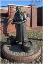 Ditzum (Gemeinde Jemgum). Die Figur Tant' Dientje steht neben demi Sieltor. 24.02.2019