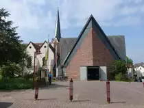 Erlenbach am Main, kath. Pfarrkirche St. Peter und Paul, Erweitertungsbau 1964 in Form eines hohen Zentralbaus auf gestrecktem siebeneckigem Grundriss mit verschiefertem Kreuzdach (13.05.2018)