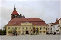 Darłowo (Rgenwalde). Das Rathaus wird vom Turm der Marienkirche berragt. 12.05.2019