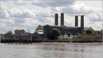 London. Die kleinen, hellen Gebude des Trinity Hospital stehen in starkem Kontrast zum mchtigen, dunklen Block der Greenwich Power Station mit seinen dominanten Schornsteinen. 09.06.2019