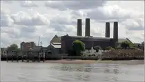 London. Die kleinen, hellen Geb�ude des Trinity Hospital stehen in starkem Kontrast zum m�chtigen, dunklen Block der Greenwich Power Station mit seinen dominanten Schornsteinen. 09.06.2019