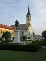 Baja, St. Peter und Paul Kirche am Toth Kalman Ter, erbaut bis 1765, davor das Denkmal f�r den Dichter Kalman Toth (24.08.2019)