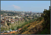 Der Fluss Mkvari hat sich unterhalb der Narikala-Festung in die Felsen hineingegraben. Direkt am Steilufer stehen die alten Wohnhuser des Stadtteils Avlabari. Seit 2012 verbindet eine Seilbahn den Stadtteil mit der Festung. Links ist die ber 700 Jahre alte Metekhi-Kirche zu sehen. (Tiflis, 17.09.2019)