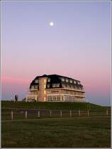 Wurster Nordseekste. Im Ortsteil Wremen thront das Hotel Upleven auf dem Deich. Darber ist am Abend des 05.05.2020 der Mond zu sehen.