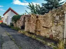 Historischer Steinzaun mit eingebautem Rastbank. Ausser der Innenstadt findet man im Stadteil Tettye noch ziemlich viel Altbau. Foto: 07.2020, Ungarn, Pcs, Kisboldogasszony utca.
