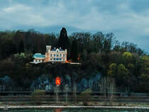 Das neugotische Schloss Marienfels und darunter eine angeleuchtete halbrunde Grotte, in der eine Mutter-Gottes-Figur aufgestellt wurde. (Remagen, April 2021)