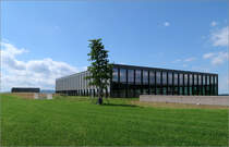 Carmen Wrth Forum mit Museum Wrth 2 - 

... in Knzelsau-Gaisbach. Rechts im Vordergrund der groe Veranstaltungsraum, links kann man den zweiten hochragend Bauteil, das Museum erkennen. Davor befindet sich unter einem knstlichen Hgel der Kammermusiksaal, der somit berhaupt nicht als Baukrper in Erscheinung tritt. Die Architektursprache ist bewusst einfach gehalten und korrespondiert mit den Industriebauten der Firma Wrth jenseits der Bundesstrae auf der Ostseite des Forum-Gelndes.

29.07.2021 (M)