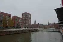 Hamburg am 16.11.2021: Blick �ber den Magdeburger Hafen mit den Neubauten der Hafencity, auf die Speicherstadt mit den T�rmen von St. Katharinen und St. Nikolai, der rechte Turm geh�rt zum Speicherstadtrathaus, der Hauptverwaltung der HHLA (Hamburger Hafen und Logistik AG, Bei St. Annen  /
