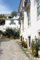 �BIDOS (Concelho de �bidos), 19.08.2019, Blick in eine Nebenstra�e der Rua Direita; im Hintergrund ist die Stadtmauer erkennbar