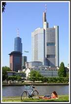 Summer in the city: Das Flussufer ist fr viele Bewohner von Frankfurt am Main im Sommer ein Ort zum Entspannen mitten in der Stadt. Am 15.07.2005 tat das auch dieser Mensch vor der Hochhauskulisse des Japan Centers und dem Main Tower im Bild links sowie dem mit 259 Meter struktureller Hhe zweithchsten Wolkenkratzer Europas, dem Commerzbank Tower. Dazwischen flog gerade ein Werbeluftschiff.